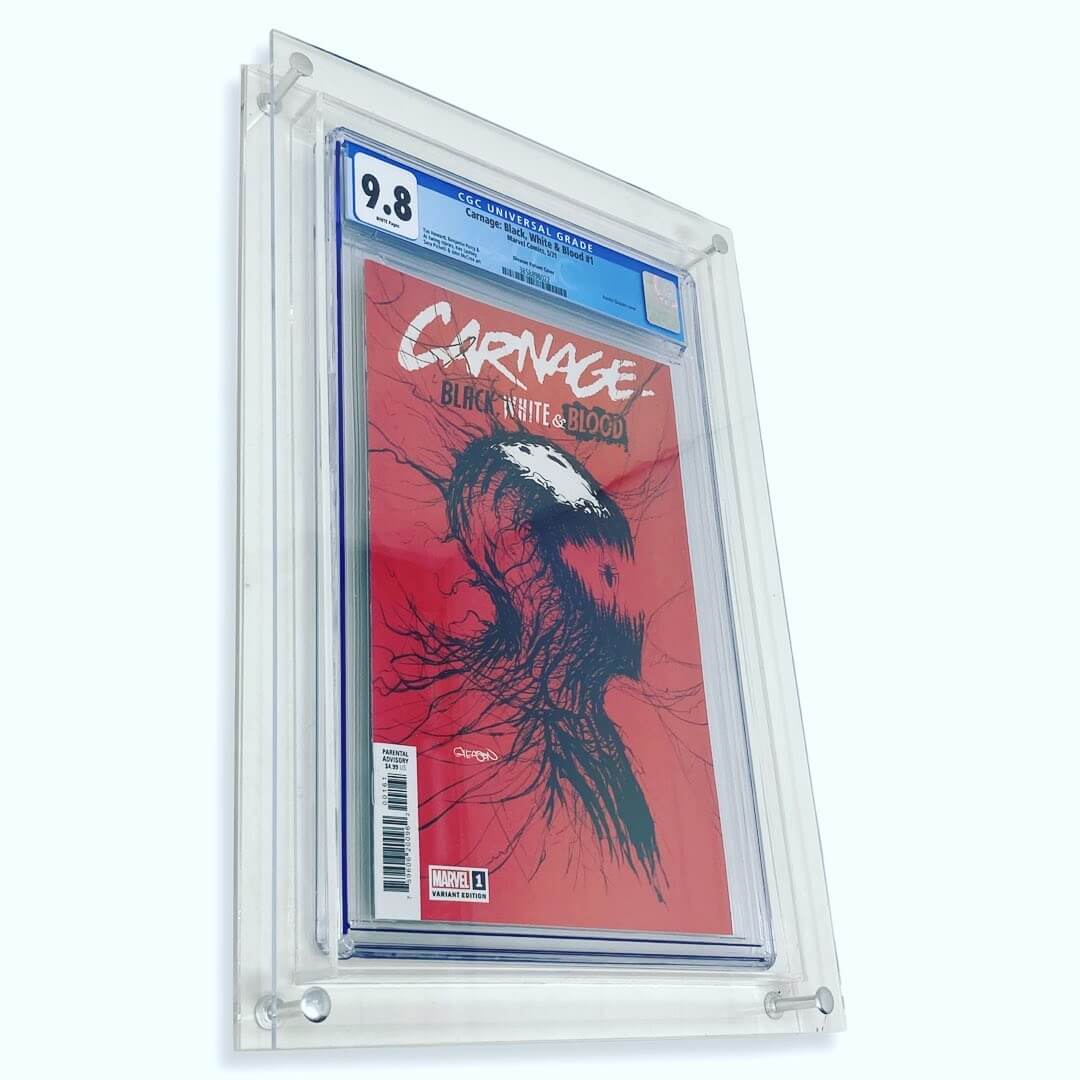 Photograph of the Crafti Comics UV-FLEX Display Case with acrylic (clear) backing. Frame for displaying graded comic books. 99% UV-protected, museum-quality acrylic standard. Hangs portrait or landscape with twin engraved mounting holes. Crafti's laser-cut layered designs provide depth without creating pressure. Inside is a copy of the Carnage book Black White and Blood